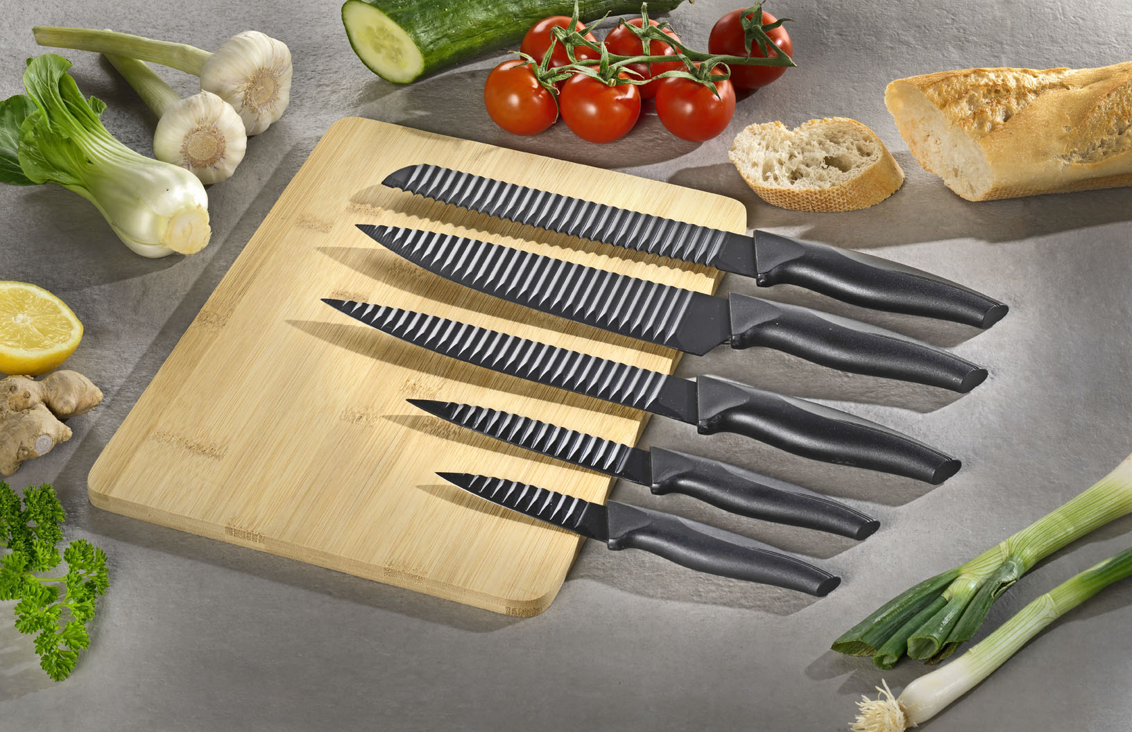 5-teiliges Messer-Set ORBIT mit Schneidbrett aus Bambus. Edelstahl-Klingen mit "Lufttaschen" gegen Anhaften, Maße Brett 31x23x1cm.